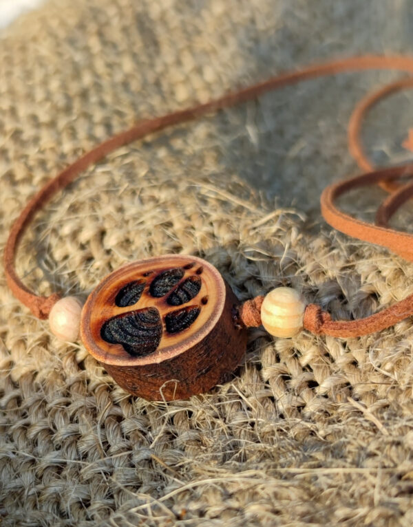 Naturholz Anhänger, Naturschmuck aus einer Baumscheibe vom Lebensbaum (Thuja) mit tief gebrannter Gravur, Motiv: Pfote, Hundepfote. Der Anhänger ist kombiniert mit Naturholzperlen & Samtband in braun