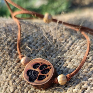 Naturholz Anhänger, Naturschmuck aus einer Baumscheibe vom Lebensbaum (Thuja) mit tief gebrannter Gravur, Motiv: Pfote, Hundepfote. Der Anhänger ist kombiniert mit Naturholzperlen & Samtband in braun