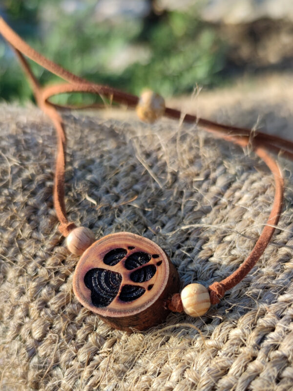 Naturholz Anhänger, Naturschmuck aus einer Baumscheibe vom Lebensbaum (Thuja) mit tief gebrannter Gravur, Motiv: Pfote, Hundepfote. Der Anhänger ist kombiniert mit Naturholzperlen & Samtband in braun